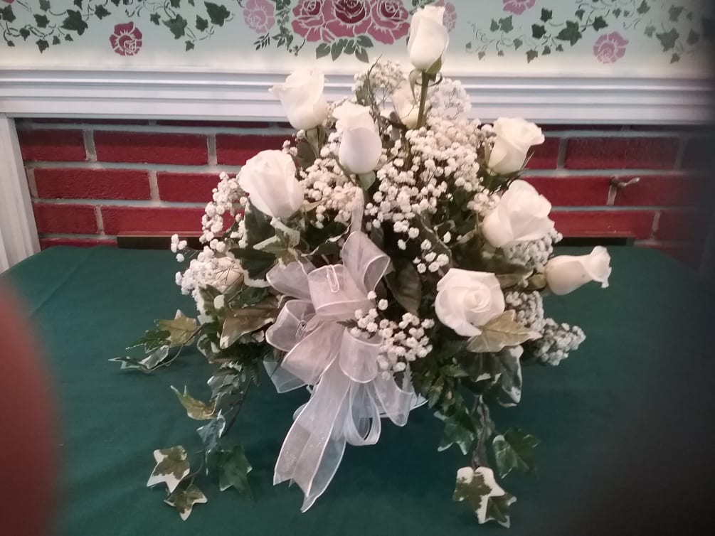 White carnations and roses with trailing ivy make this basket unique for