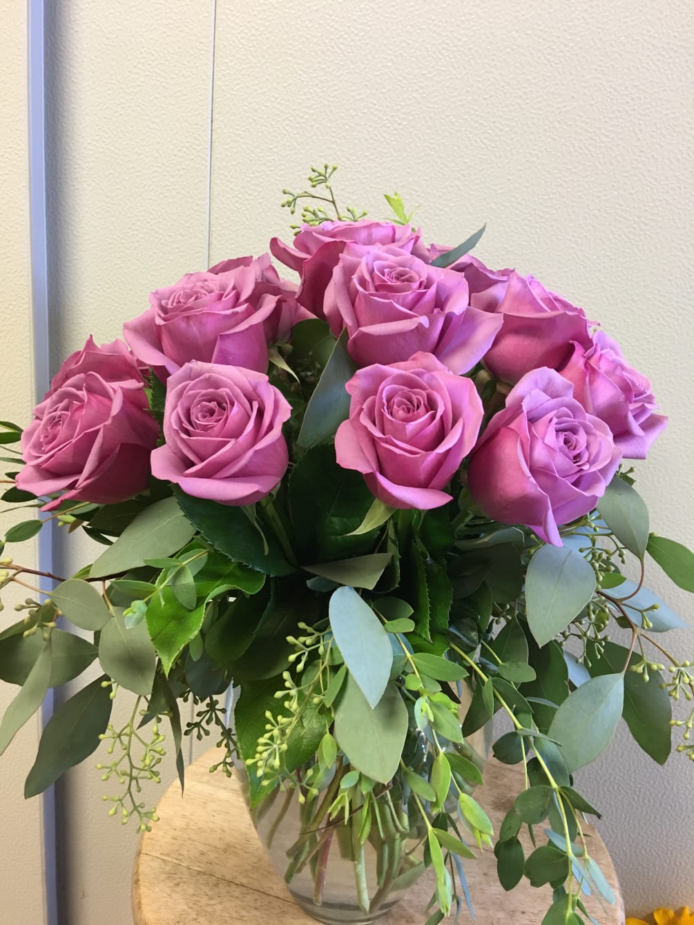 A dozen of lavender roses with greens in clear vase. Romantic Lavender