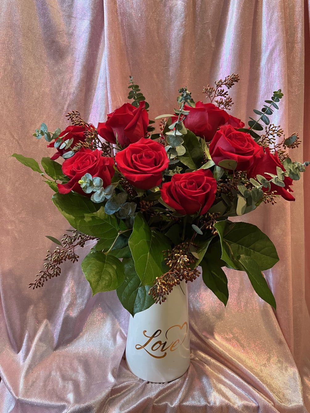 A gorgeous presentation of 1 dozen red roses accented with eucalyptus and