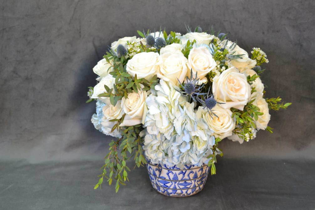 This Chinese vase with White Roses, Hydrangeas, Blue Thistle and fillers is
