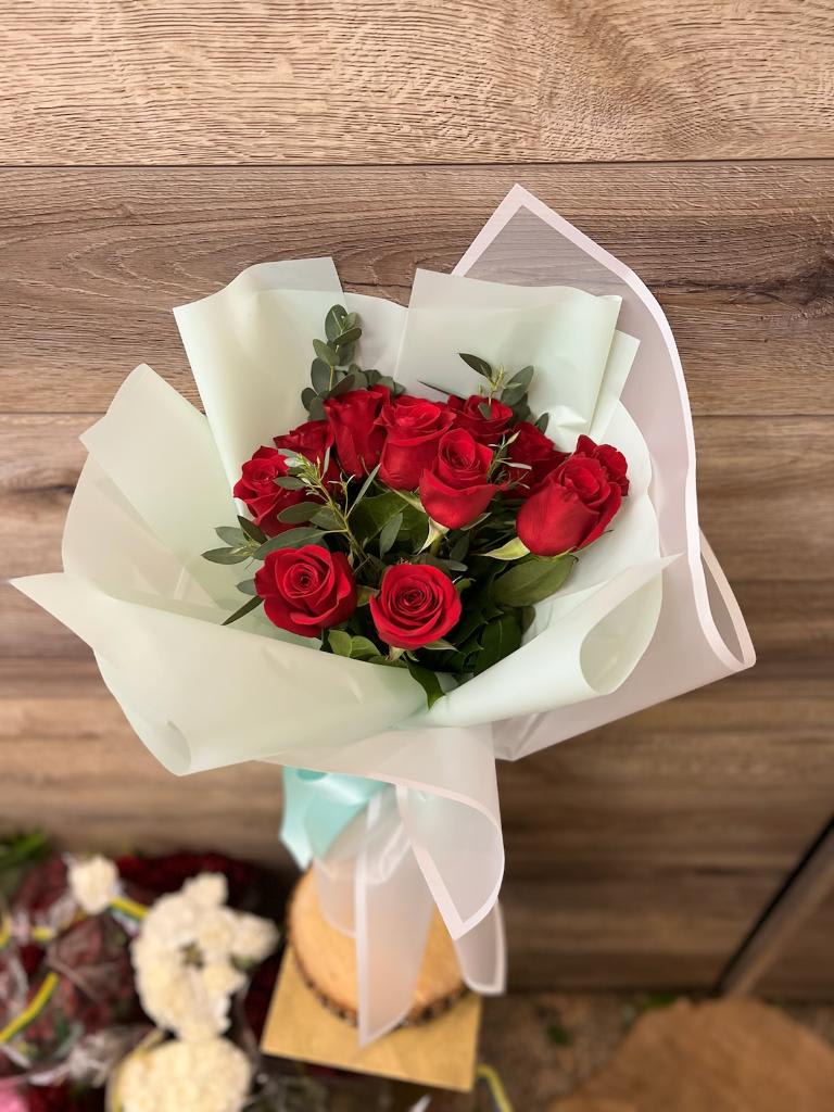 Red roses hand bouquet with light blue / green and white wrapping