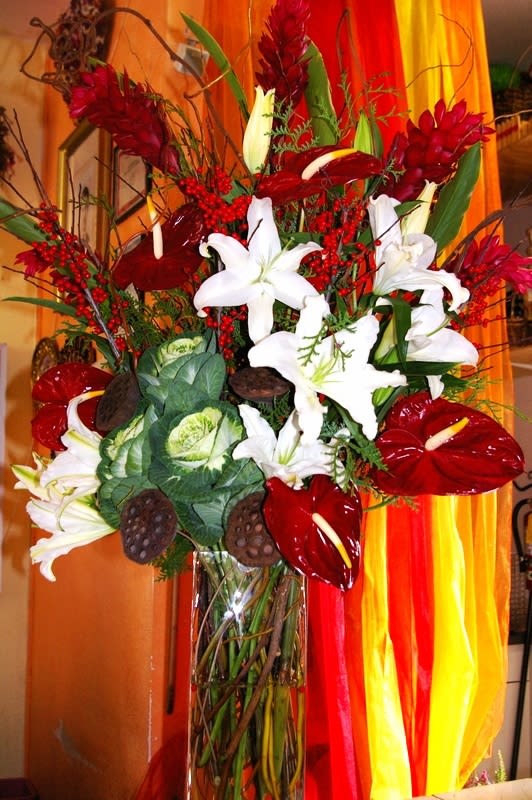 Wine colored anthuriums, casablanca lilies and ilex berries in vase