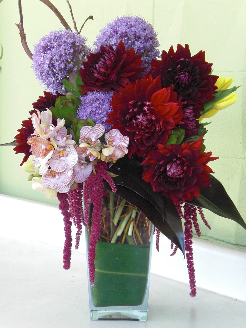 Gorgeous combination of dark burgundy dahlias, purple alium, yellow tulips and mini