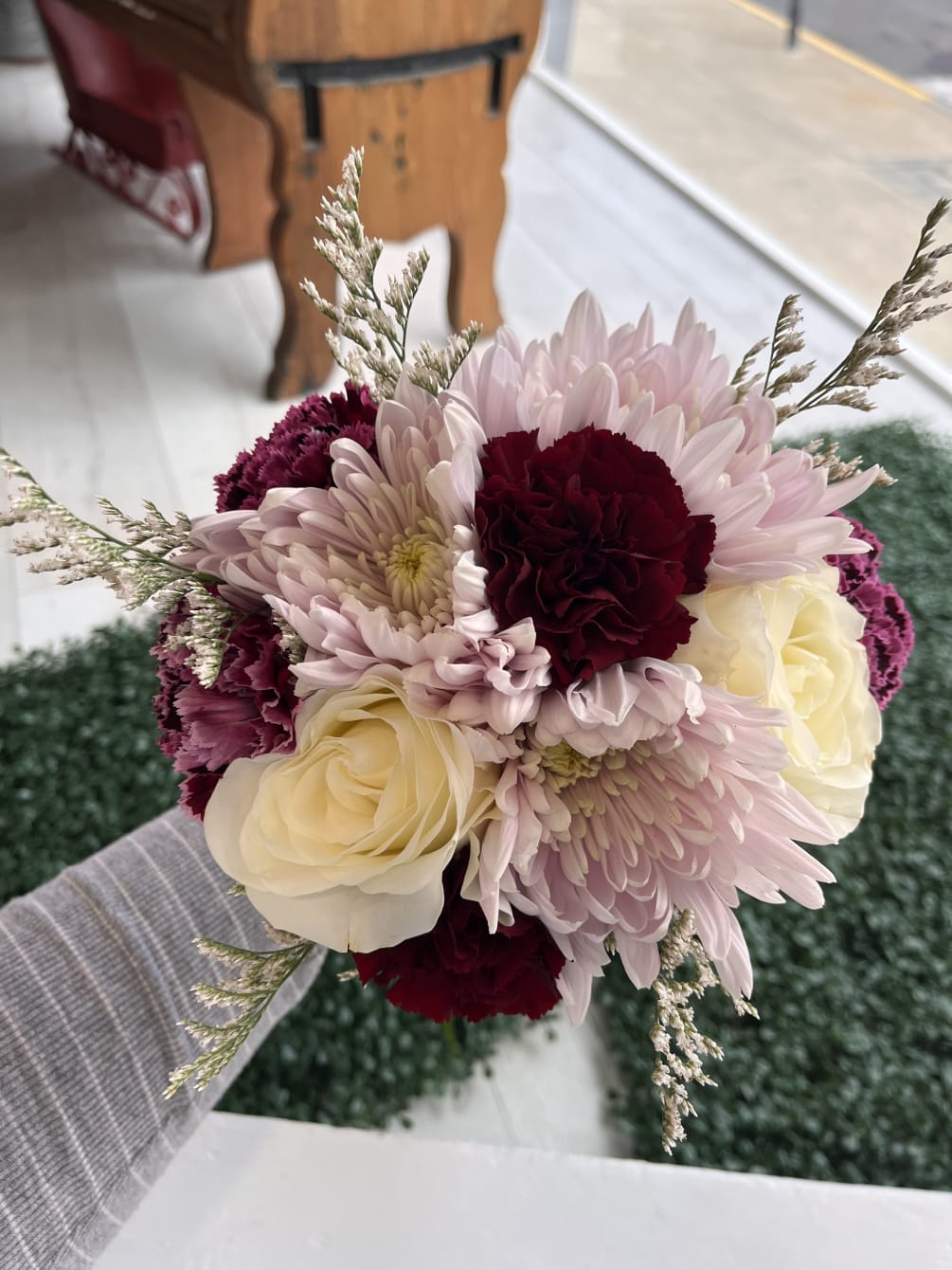 handheld bouquet with lavender, burgundy and purple flowers. finished with fresh greenery