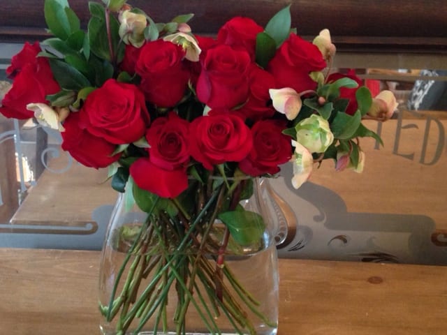 24 Red Roses and Helleborus And Lemon Verbena in a glass vase