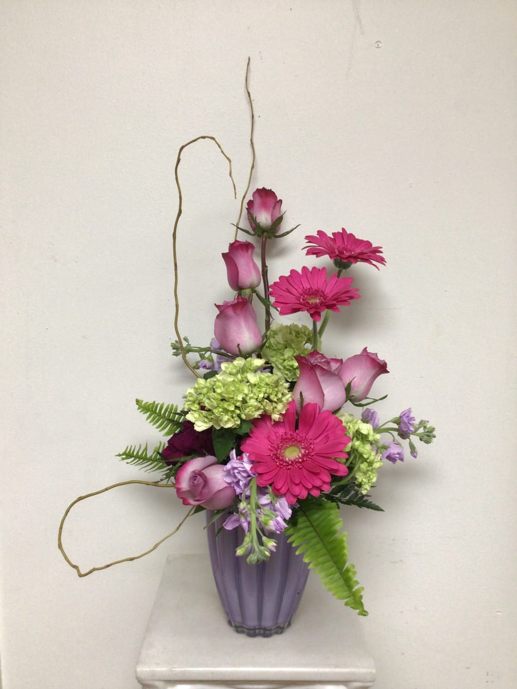 This contemporary arrangement is arranged in a lavender clam shell vase and
