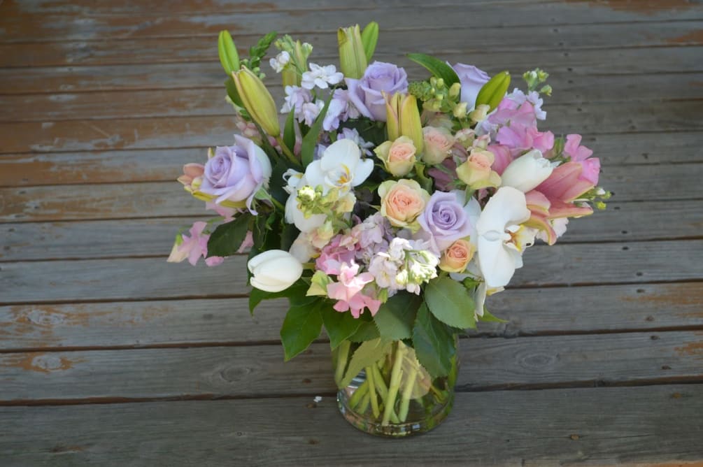 Delicate orchid blooms, lavender roses, pink stock, peach spray roses, lilies 
all