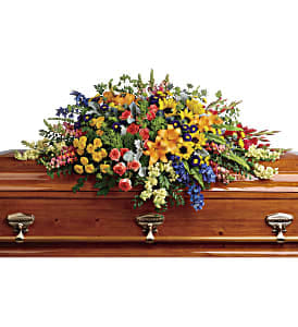 Full of light and love, this colorful casket spray celebrates a bright