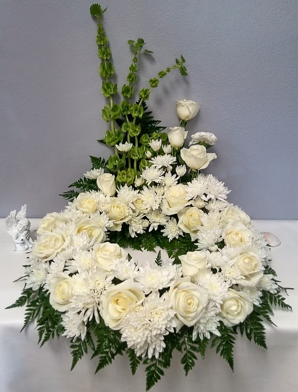 This white wreath with greenery will grace your loved one&#039;s urn with