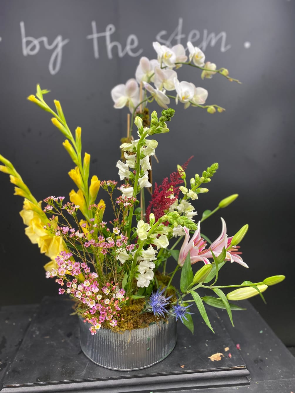 Beautiful spring flowers accompany a double stem white Phalaenopsis orchid in this