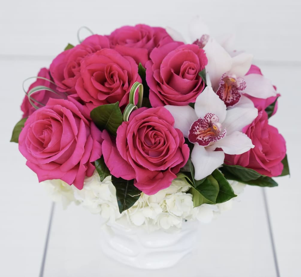 Roses and Orchid bloom accents on a bed of hydrangeas in a
