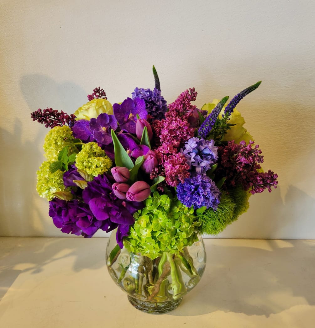 a low and lush arrangement with a beautiful combination of purple flowers