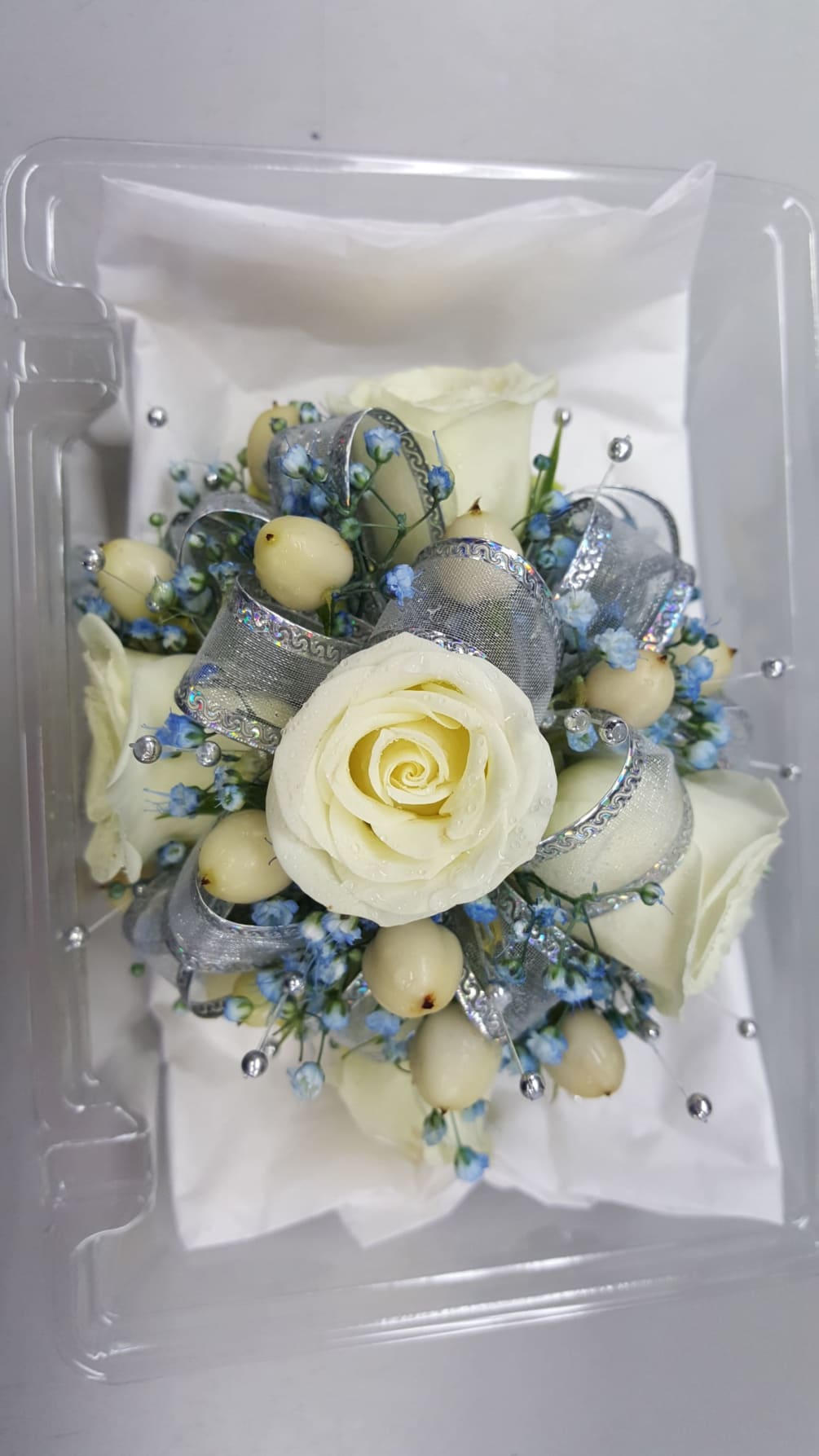 White Spray Roses, Blue Baby&#039;s Breath, Silver Accents, Silver Ribbon. 