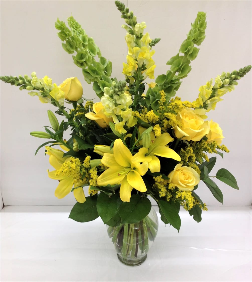 Roses, lilies, snapdragons, solidago and bells of Ireland beaming beautifully anywhere they