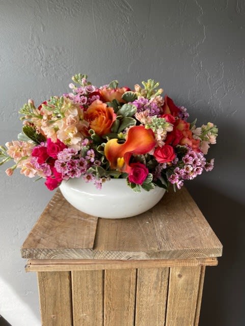 A generous sized white ceramic bowl filled with brightly colored flowers.
