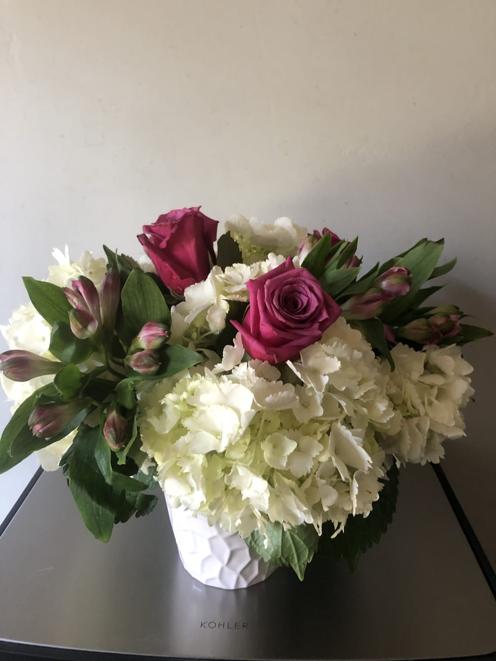 White hydrangea and roses in a ceramic container 