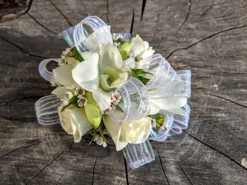 Shown as Standard
White orchids, white spray roses, white waxflower, greens and white