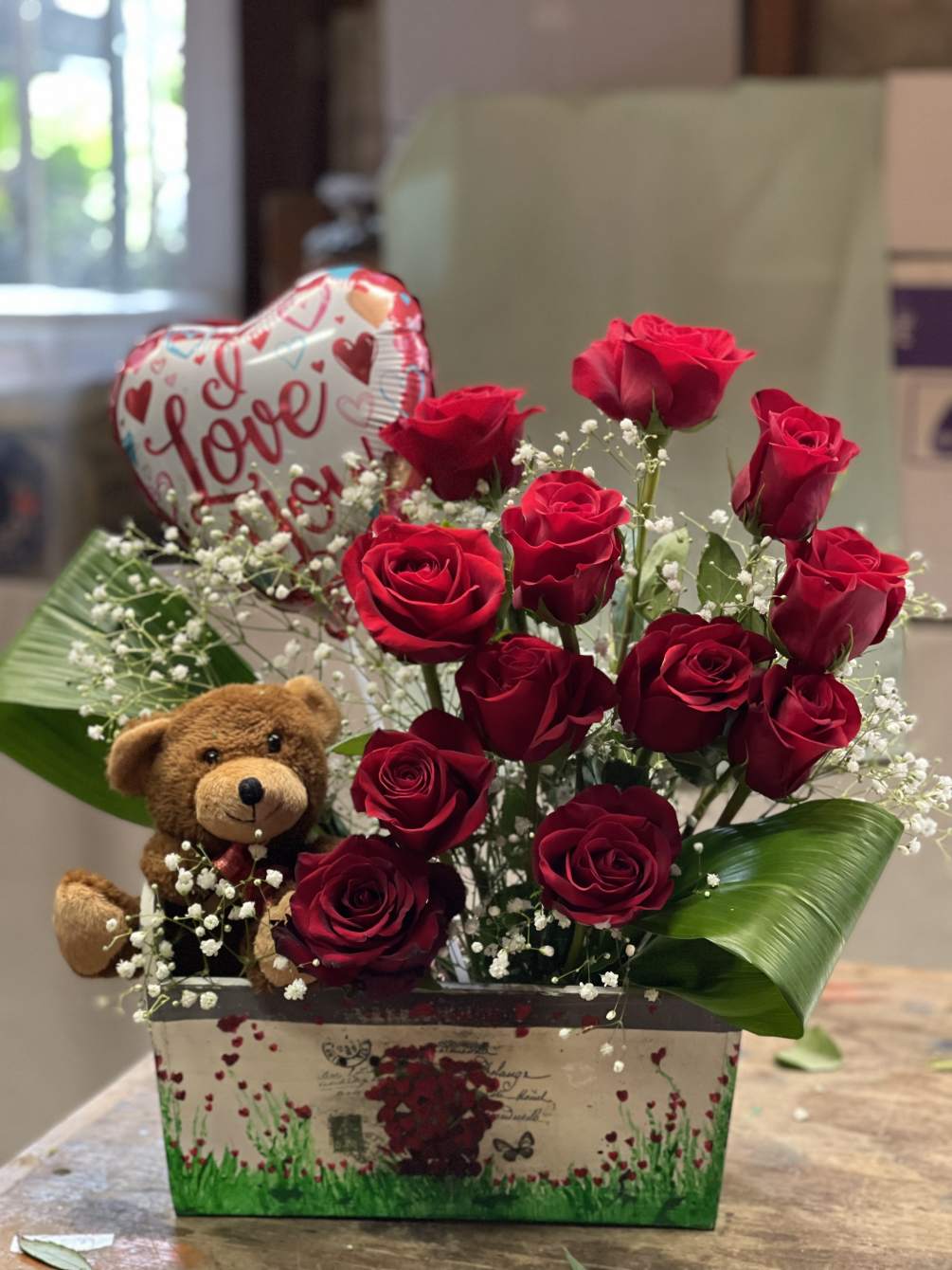Cute arrangement of 12x roses, a teddy bear, and a valentines balloon