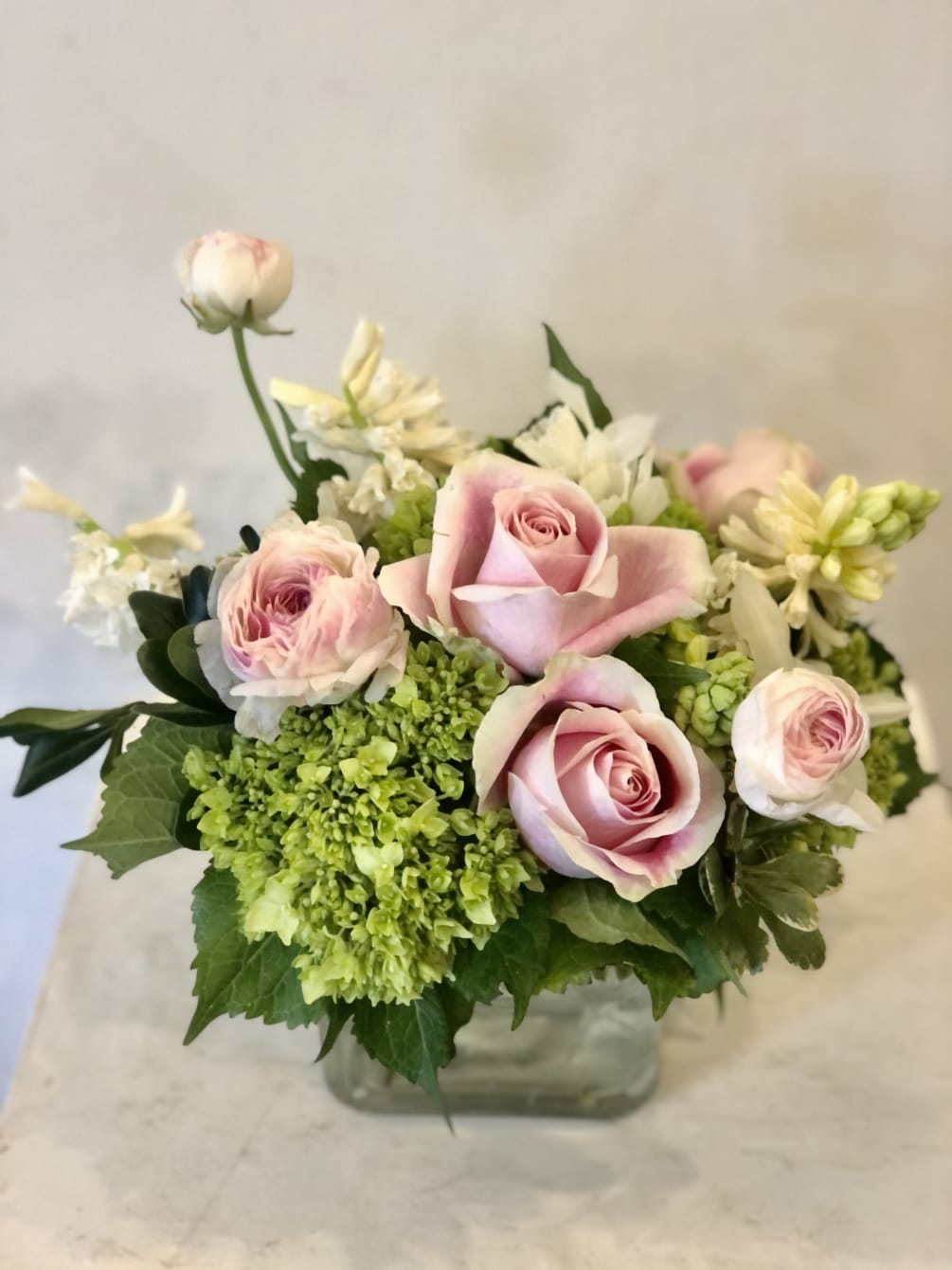 Pink roses, white Hyacinths, pink ranunculus, and mini green hydrangea, ranunculus in
