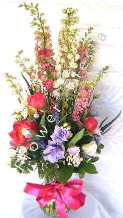 An amazing full flower arrangement with a gorgeous bow and quality vase