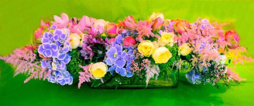 Arrangement with purple, pink, and yellow flowers.