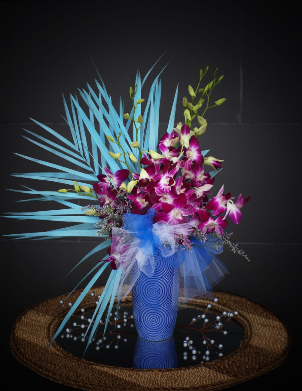 Ocean Breeze design including orchids and palm leaves in a nice vase.