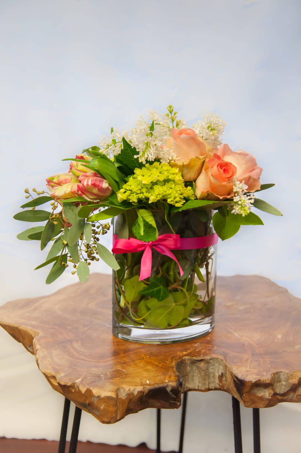 French tulips, hydrangea, roses, and seeded eucalyptus arranged in a modern oval