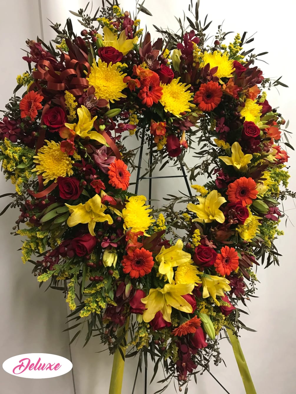 This open heart arrangement is a lovely assortment of autumn colored flowers.