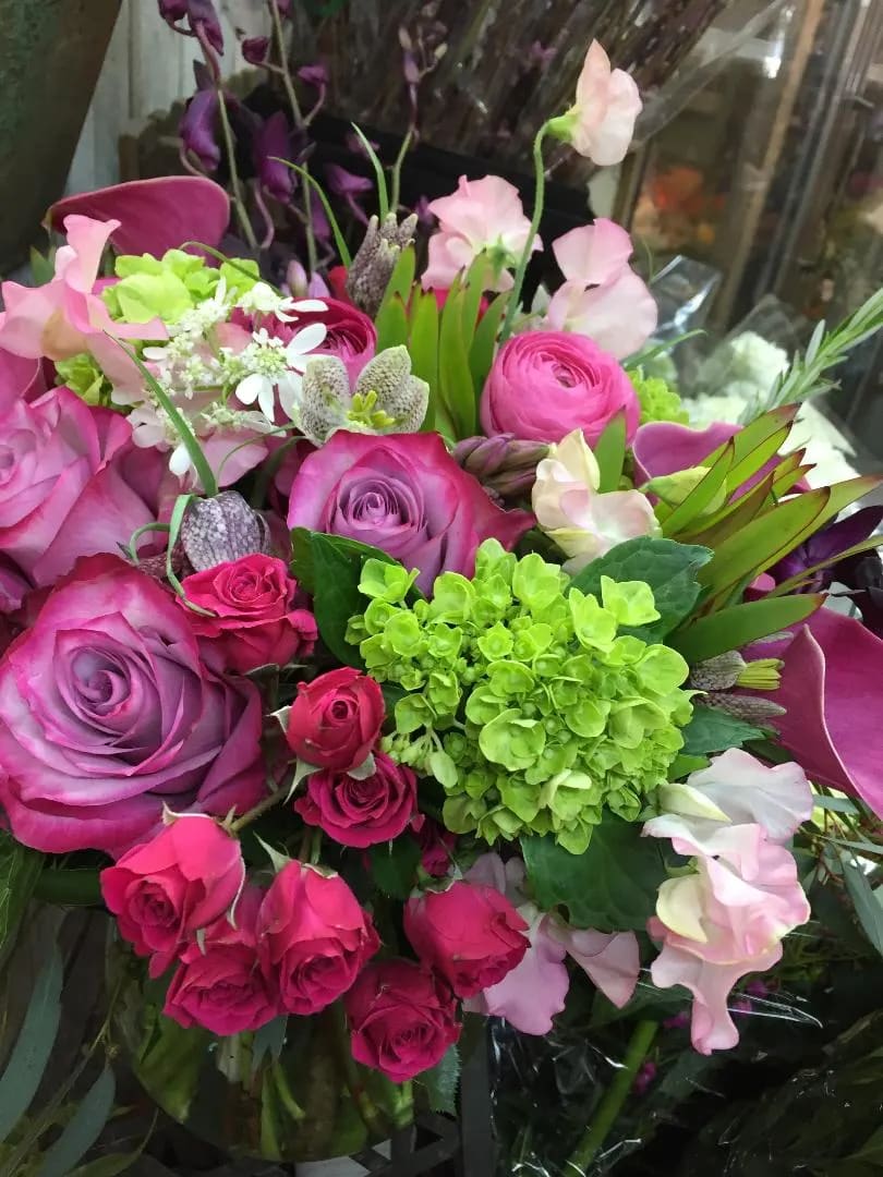 Purple roses, pink ranunculus dance with sweetpeas and calla lilies on a