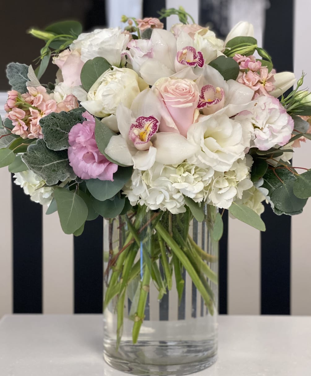 Tall size vase with soft colored blooms in pinks and whites. 