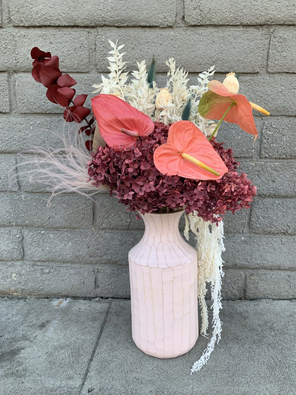 Sustainable composition in a vase with dried florals and fresh Anthurium.