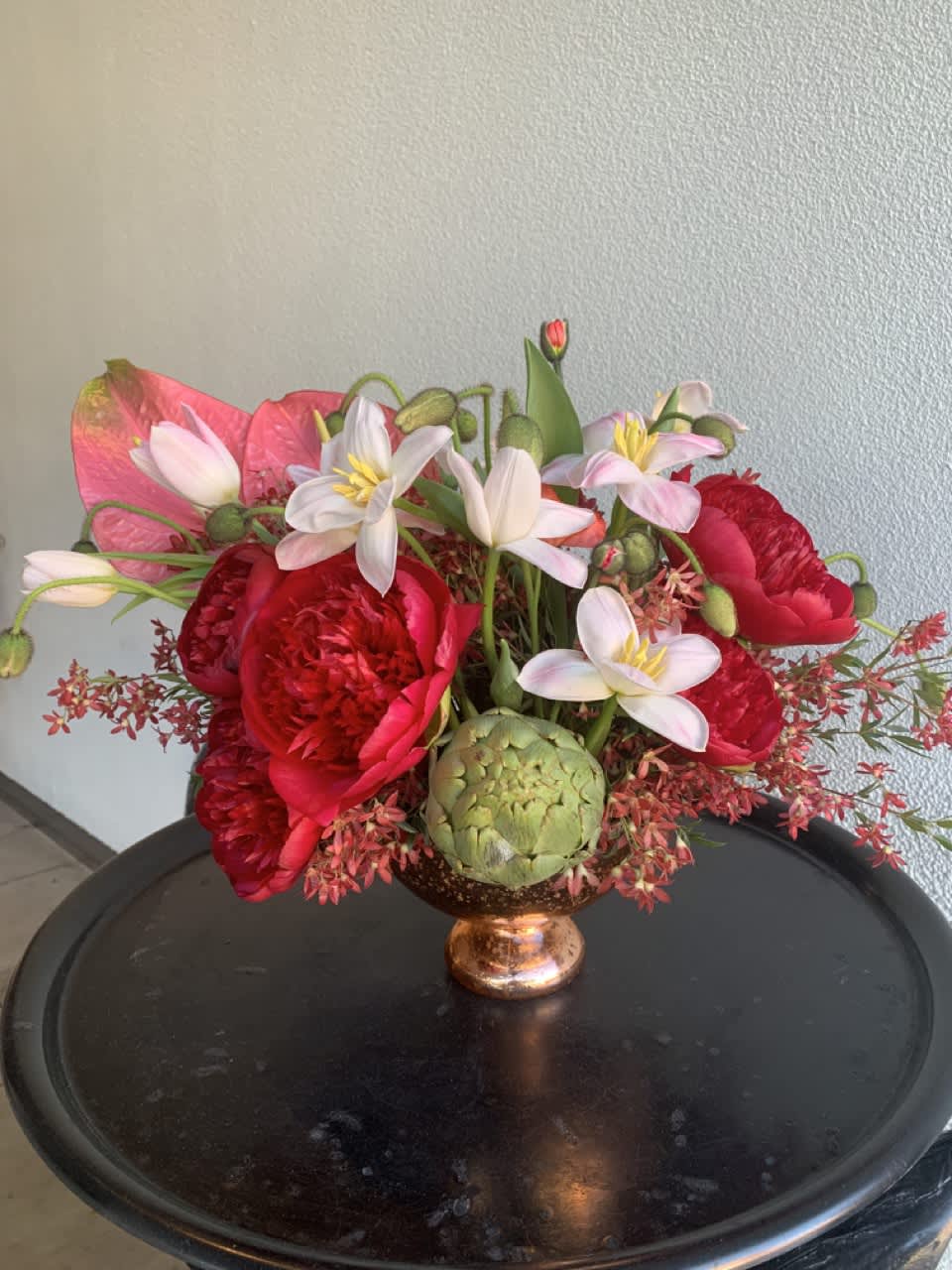 Sustainable composition with red Peonies, Tulips and Artichoke.