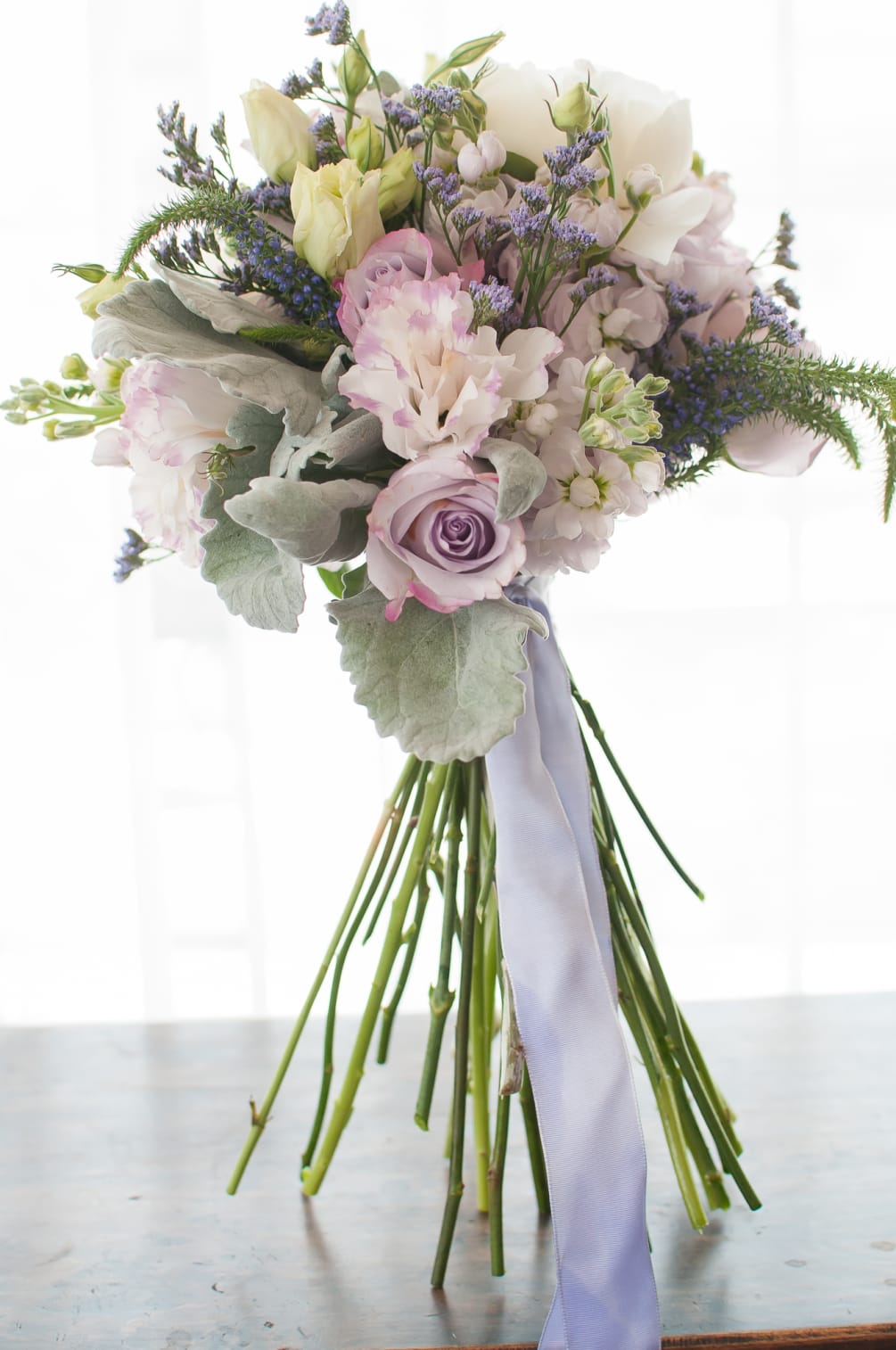 Gorgeous mix of lavender flowers including misty, roses, stock, and dusty miller.