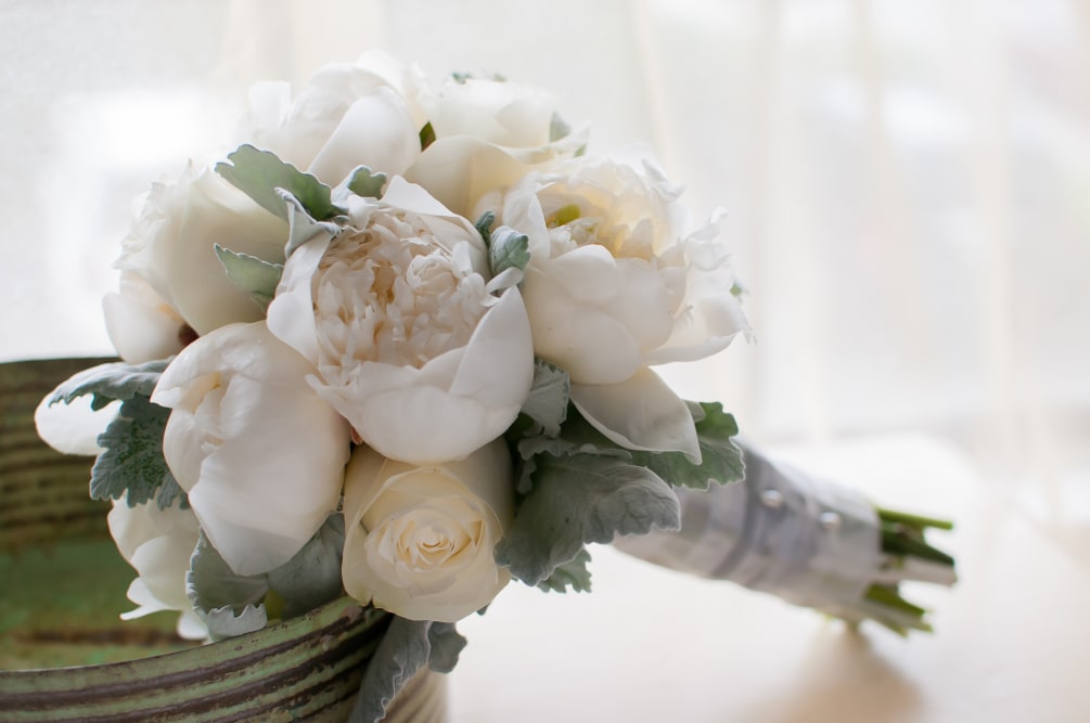 Petite hand tied bouquet made up of roses, fragrant peonies and garnished
