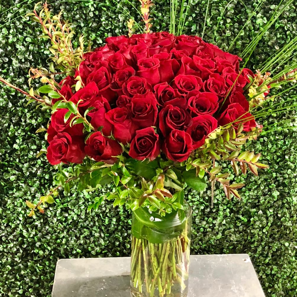 Tall glass vase with 50 beautiful red roses and greenary 