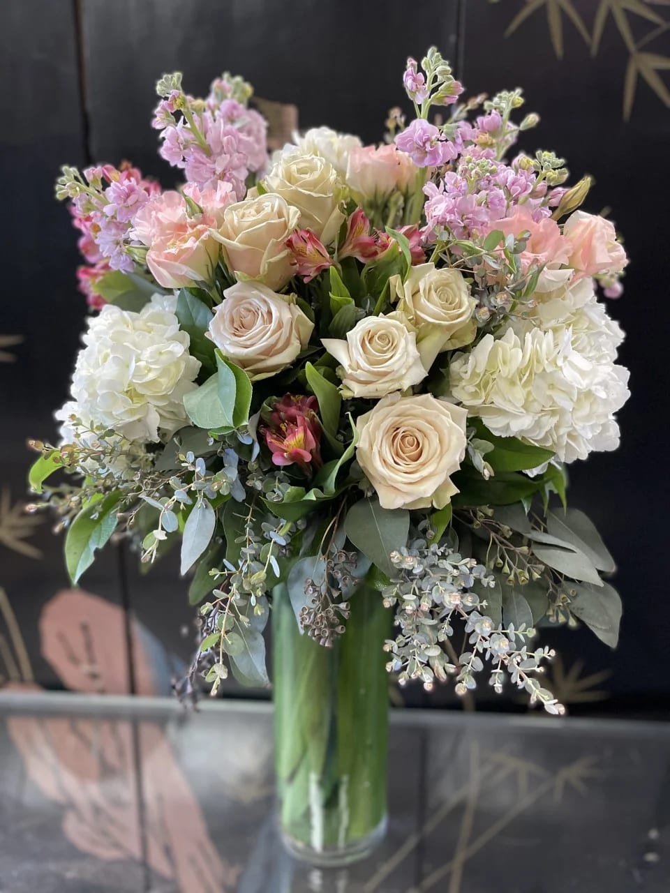 CREAM ROSES SURROUNDED BY HYDRANGEA AND MIX OF PINK FLOWERS AND LUSH