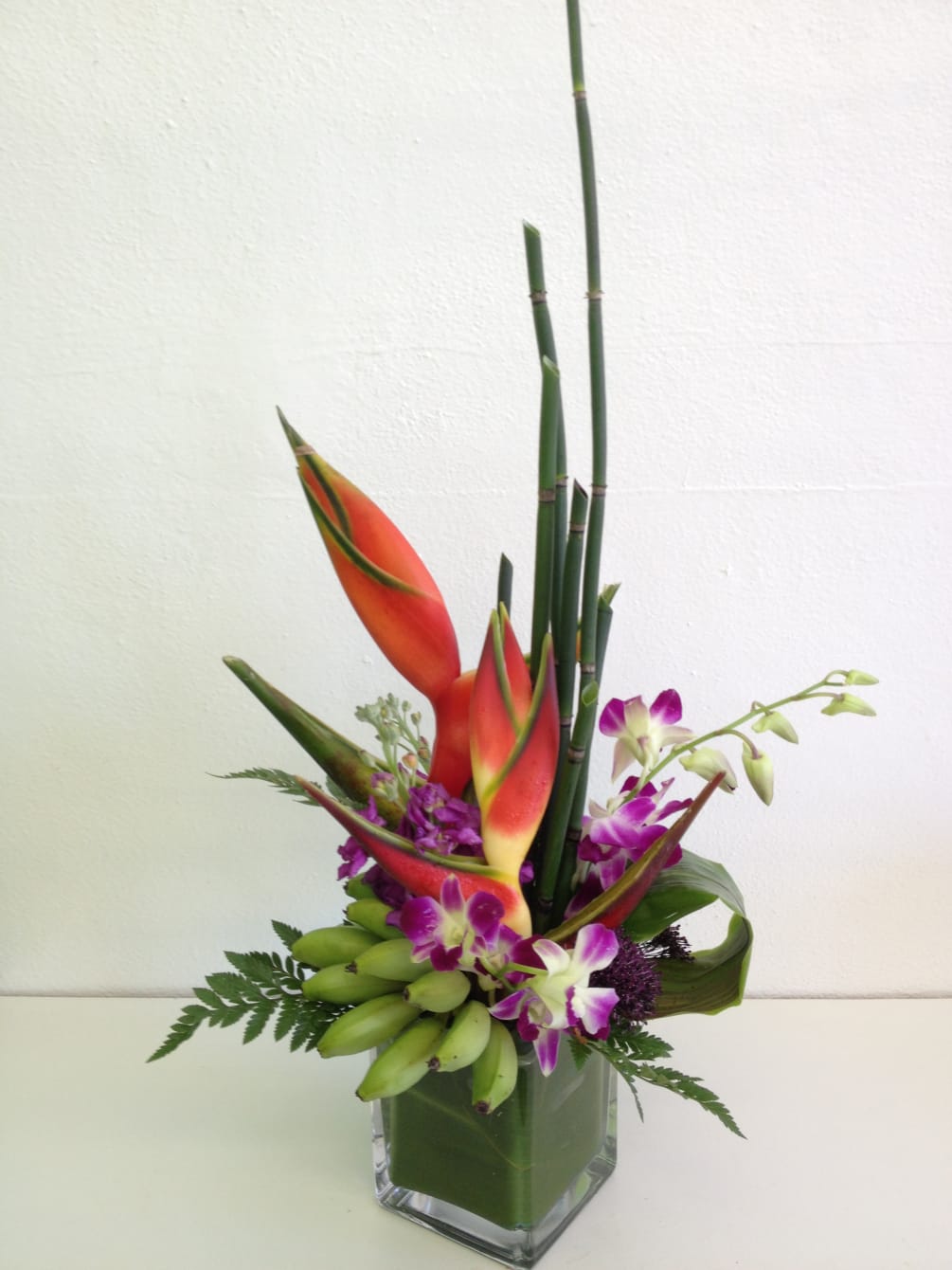 This tropical was created with haliconias, stock, orchids, tropical greens and of