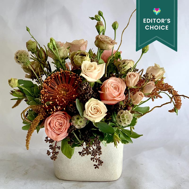 An elegant combination of warm earth toned flowers paired with seasonal foliage.