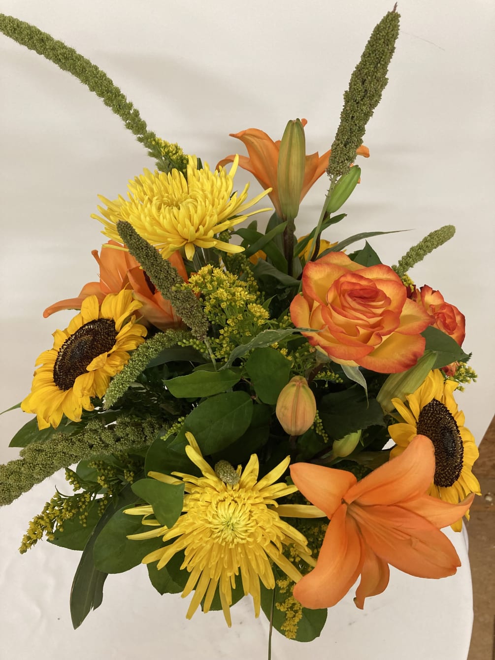 Orange  lilies and roses with yellow sunfowers and spider mums surrounded