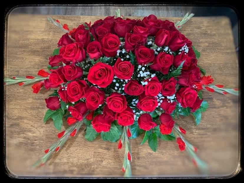 Beautiful and elegant casket spray of red roses.