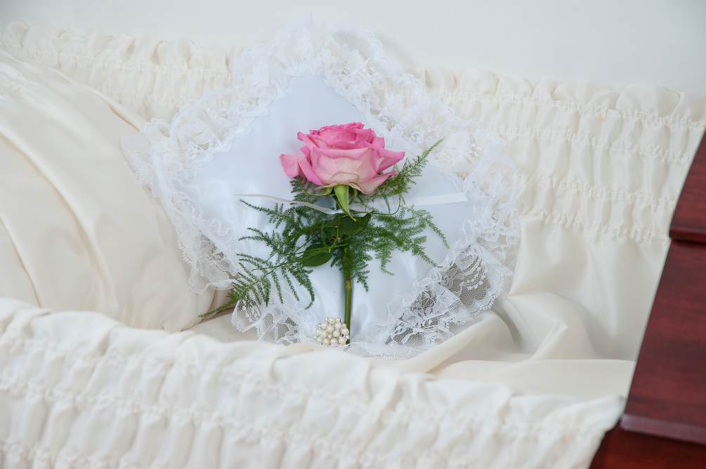 A satin pillow enhanced with a single rose. Approximately 8&quot;W