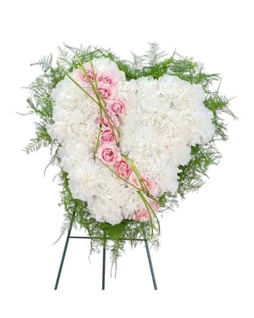 A sweet white heart of white carnations with roses to symbolize the