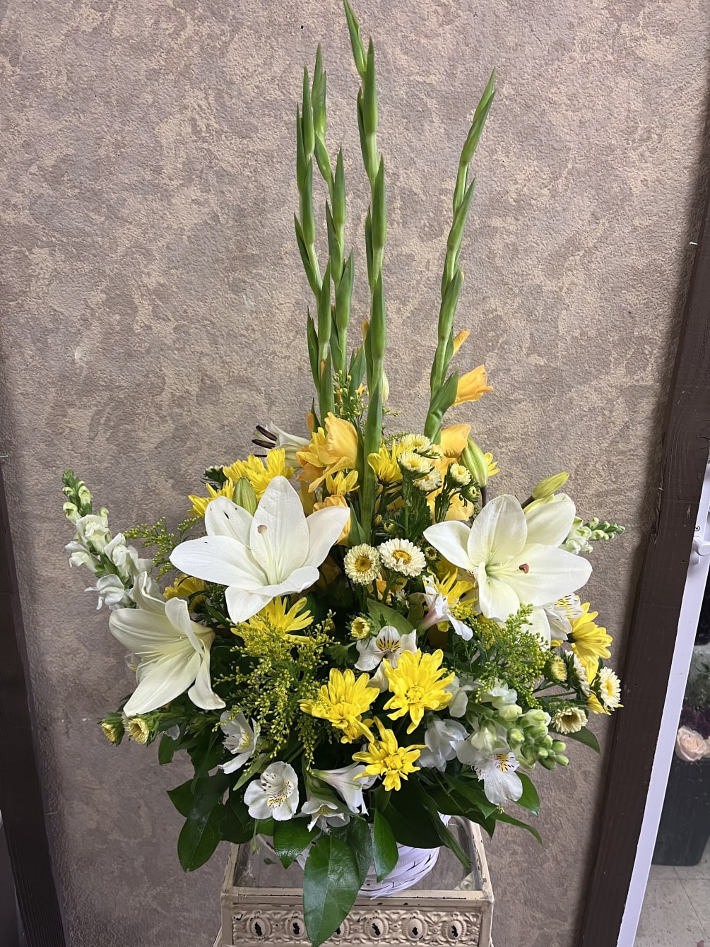 Stunning Gladiolas, lilies, larkspur, roses, alstroemerias, chrysanthemums, in a white basket vase.