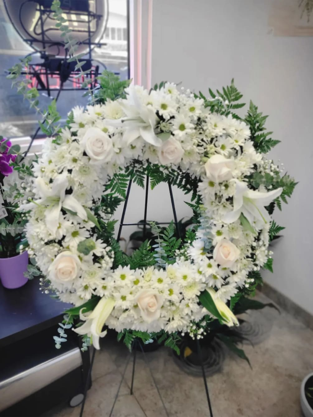 A beautiful white and green tribute wreath that calms, this easel arrangement