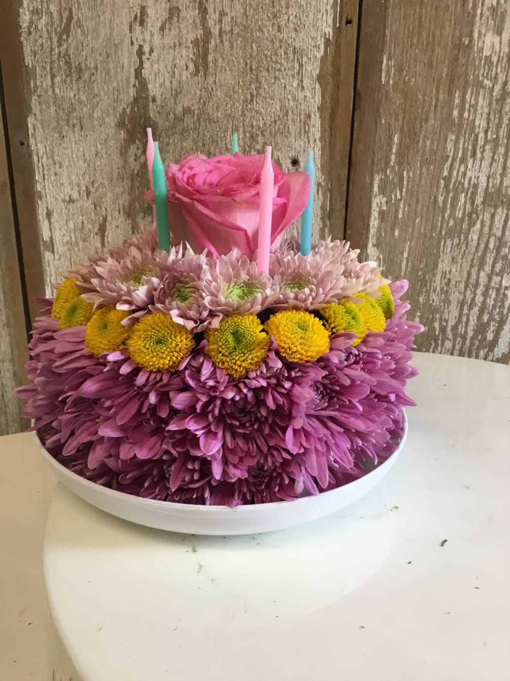 Assorted mums, Daisies, Roses or Buttons in the shape of a Cake