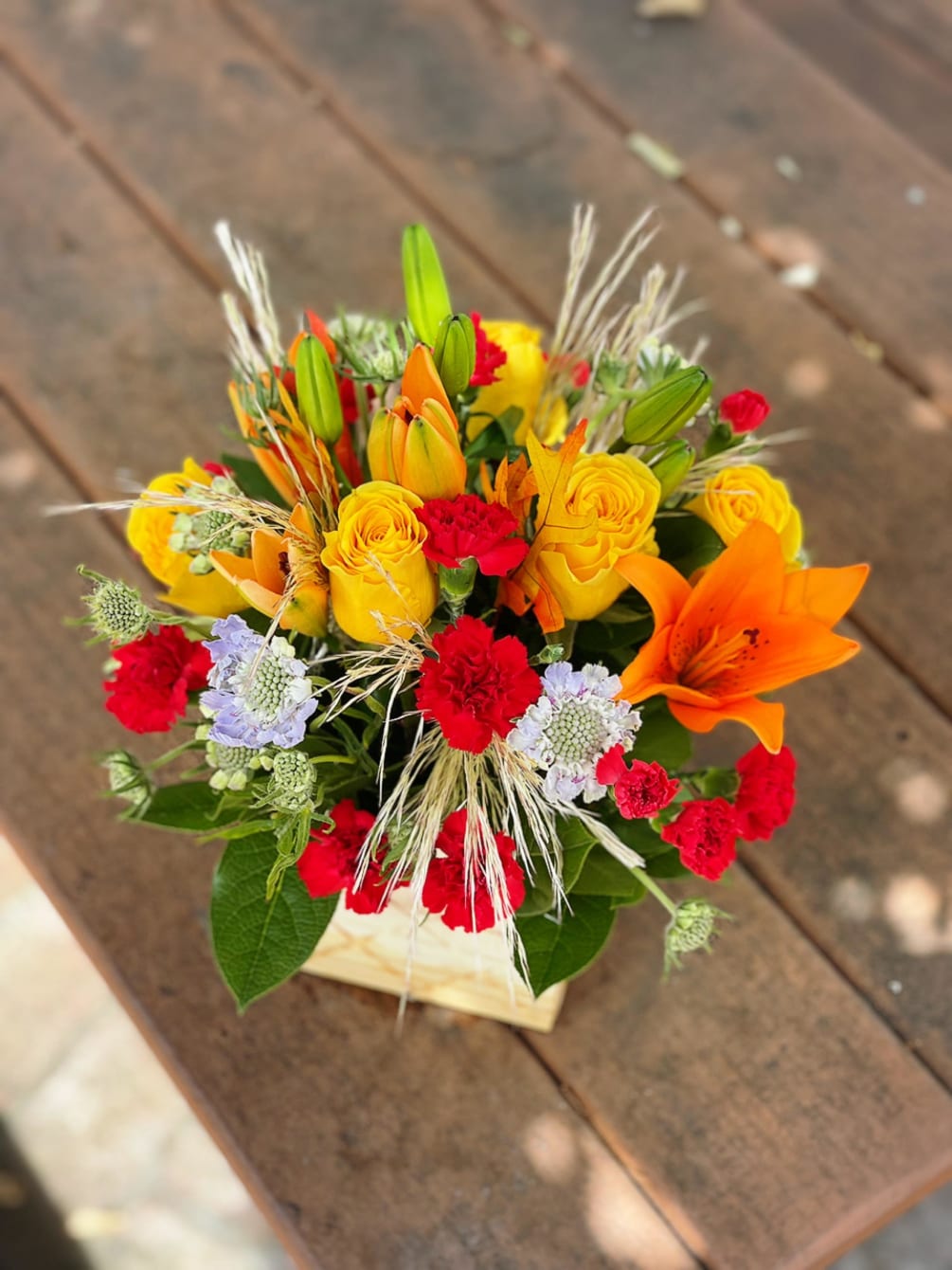 - 2 Orange Lilies
- 6 Yellow Roses
- 5 Red Carnations
- White Fillers
-