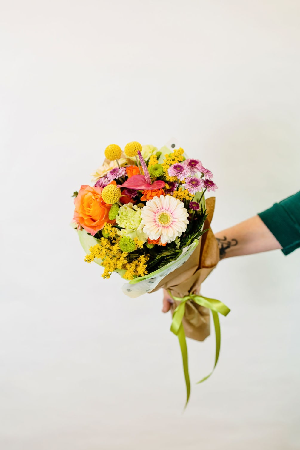 This hand tied bouquet is a collect of bright and cheery seasonal