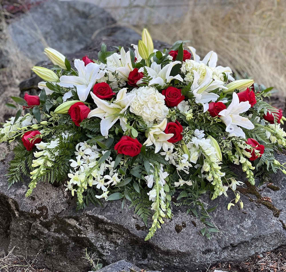 Casket spray,  shades of red and white,  with orchids, 