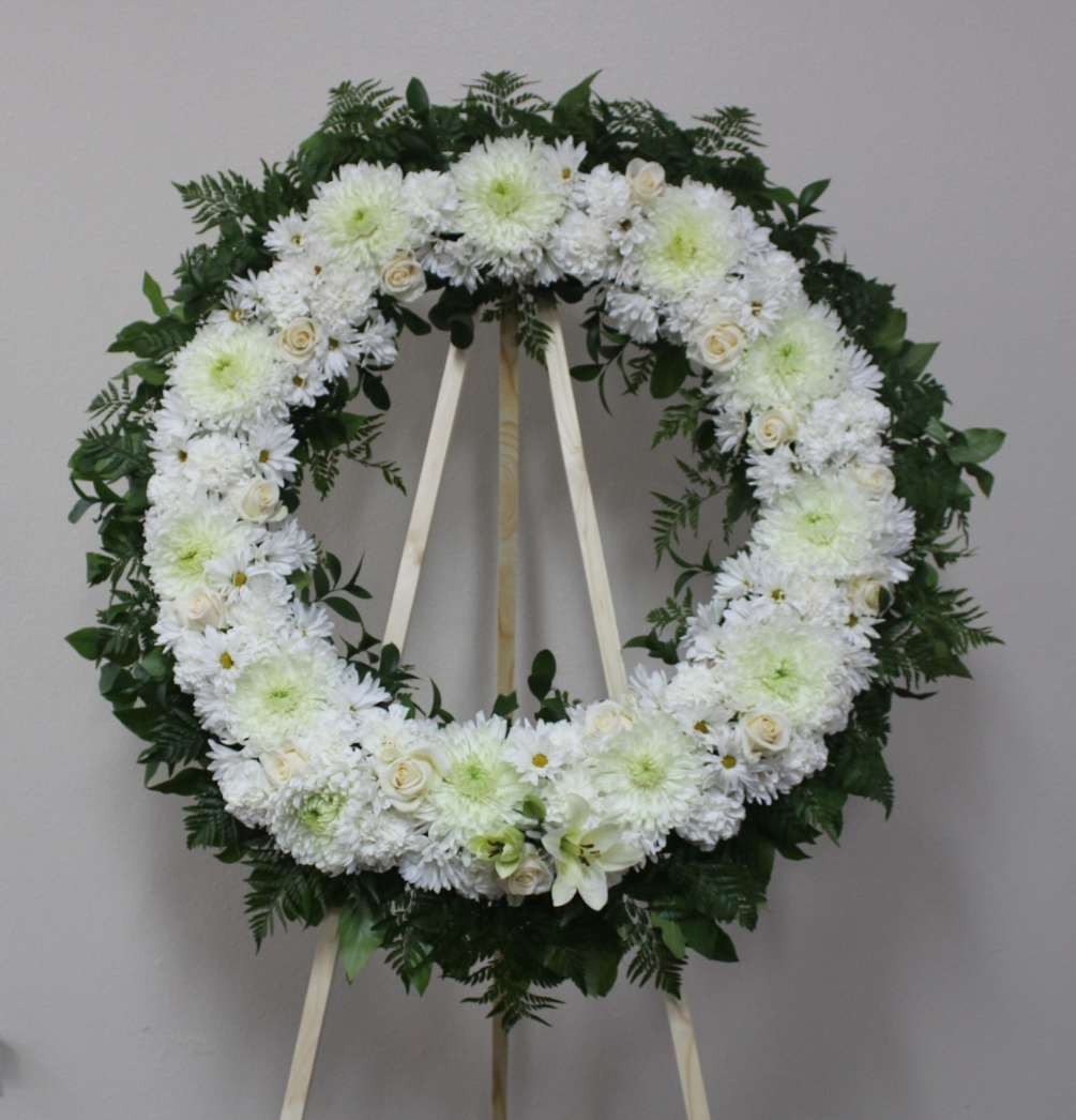 A beautiful white tribute wreath that calms, this easel arrangement celebrates a