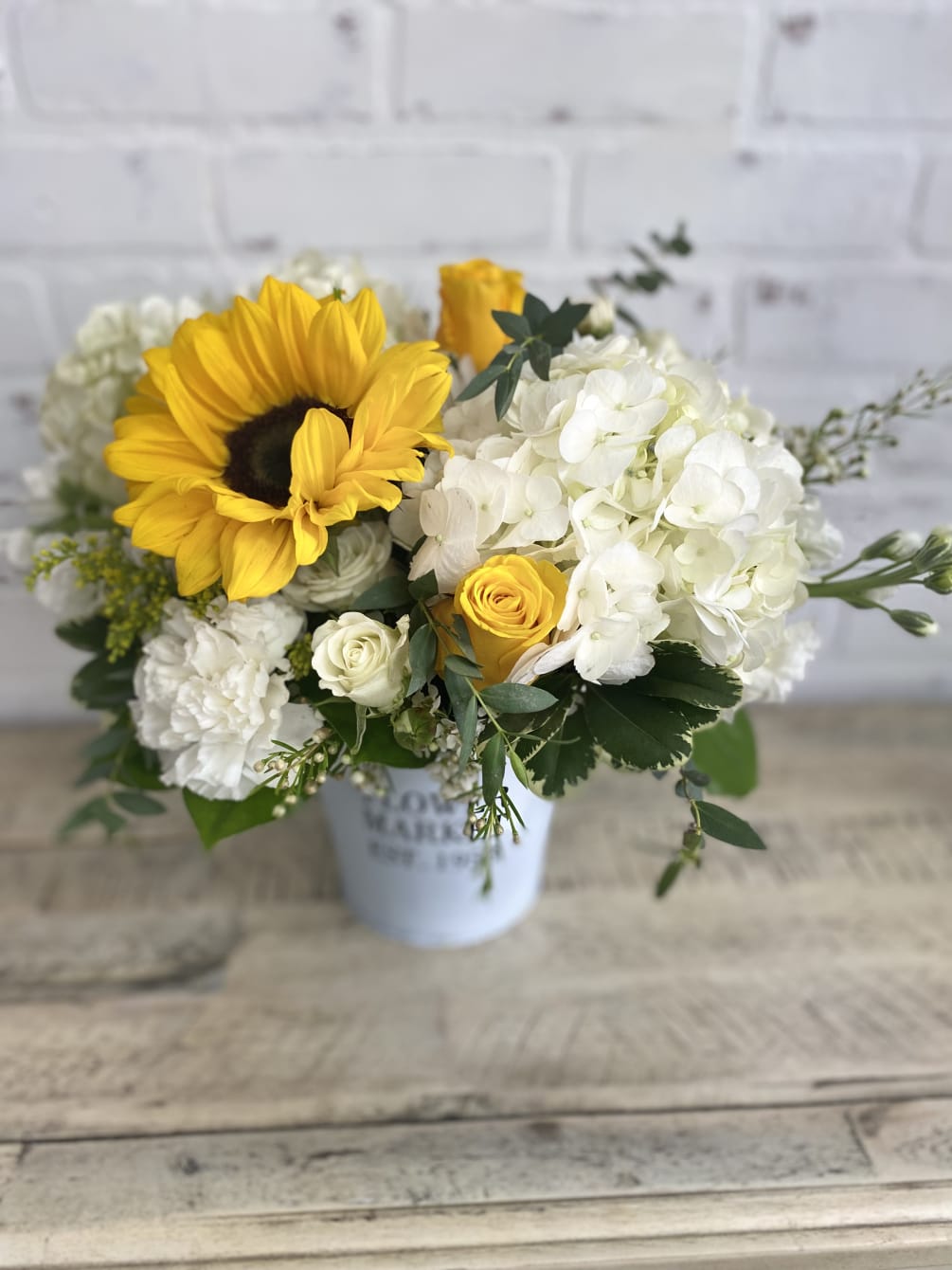 Yellow and white blooms arranged delicately in a flower market container